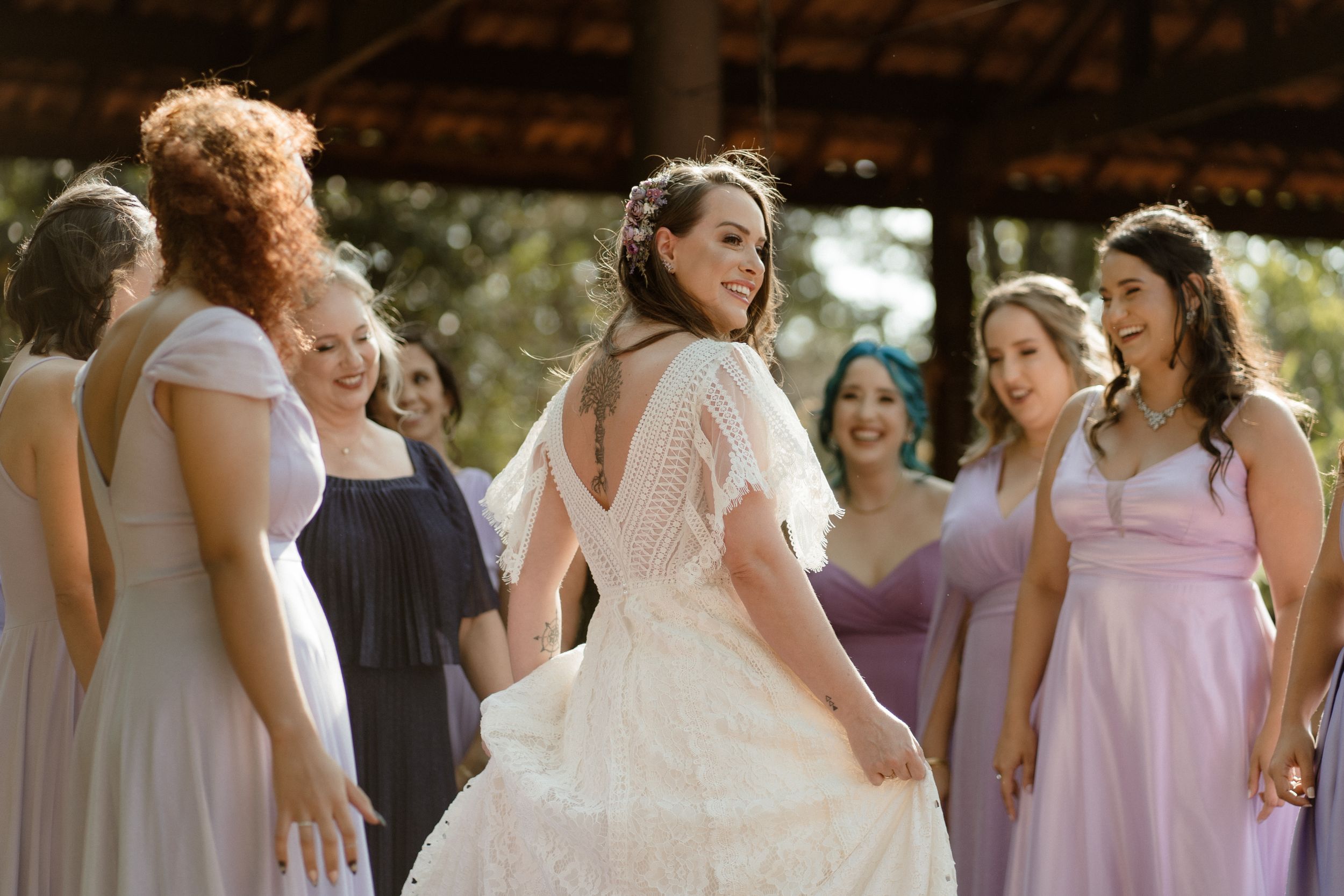 Wedding party in purple and white dresses share a candid moment outdoors.