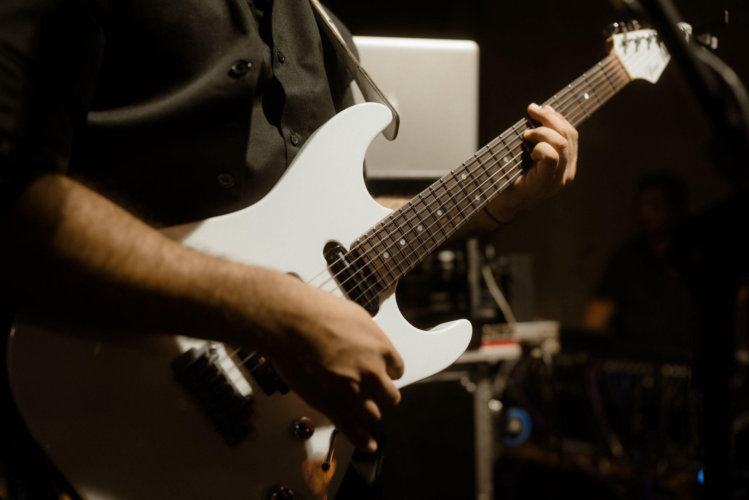 Close-up shot of hands playing electric guitar during a live performance.