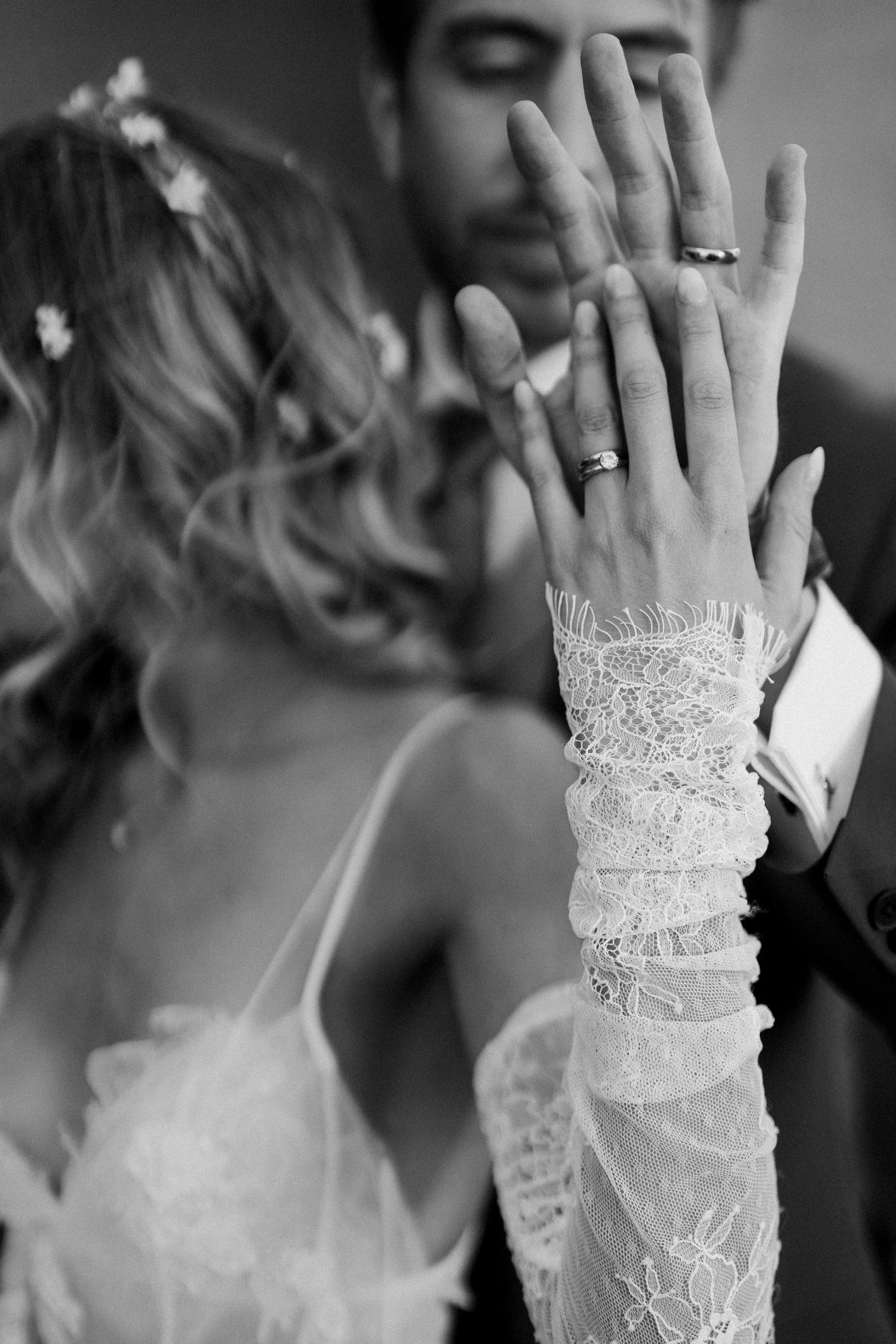 Black and white detail shots of delicate lace bridal gloves and wedding rings.