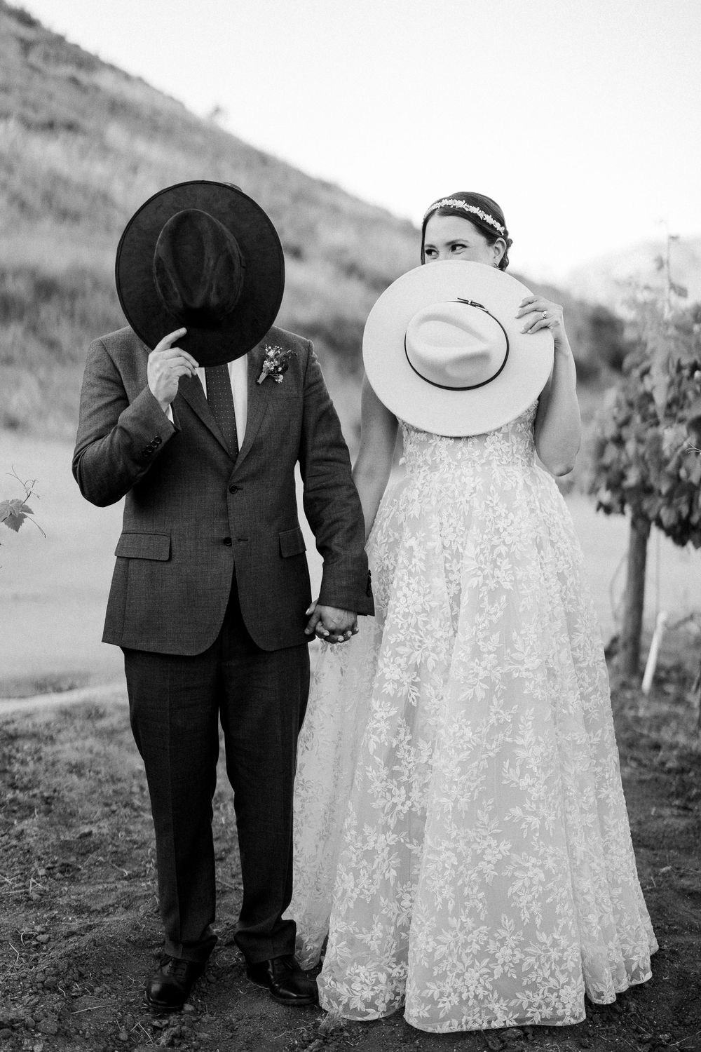 Black and white artful series showing a couple in formal attire walking together through a scenic outdoor setting.