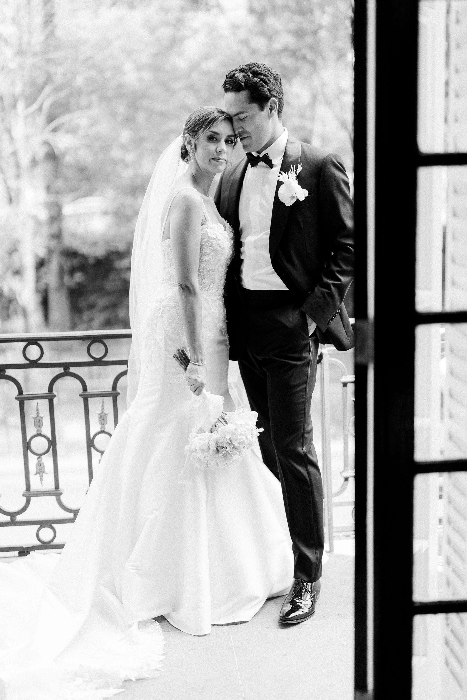 Black and white wedding portraits captured through window reflections.