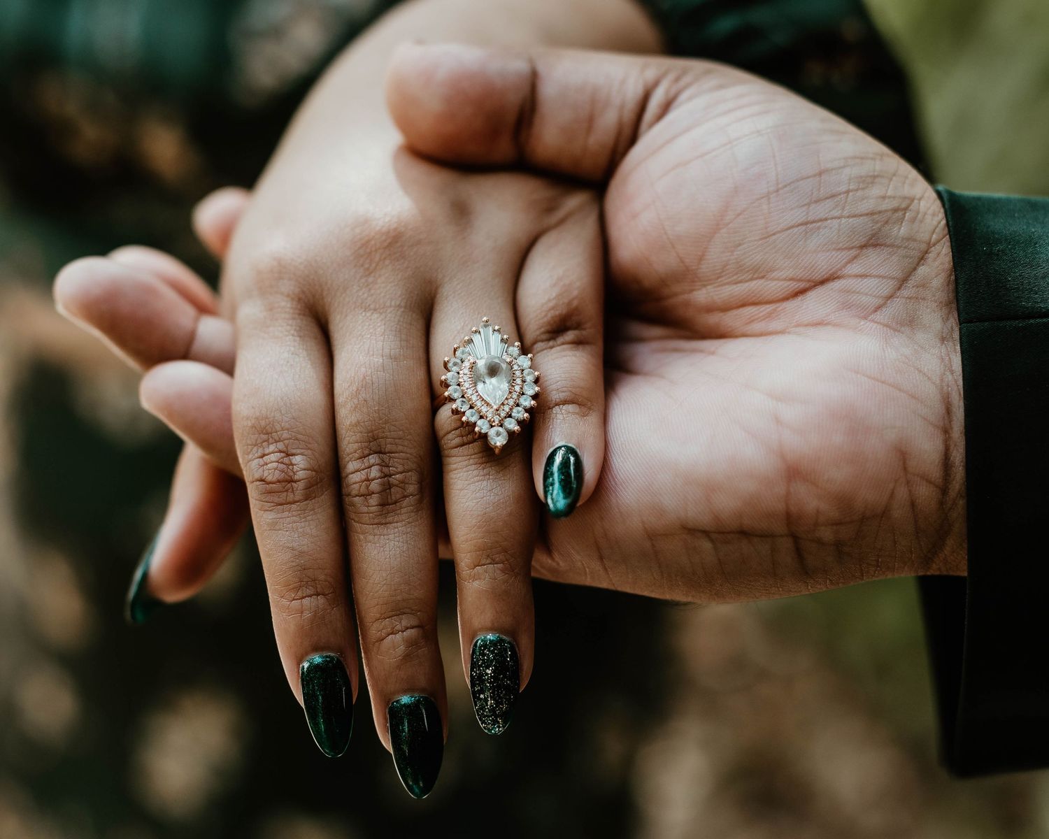 Close-up sequence of engagement rings and manicured hands with dark nail polish.
