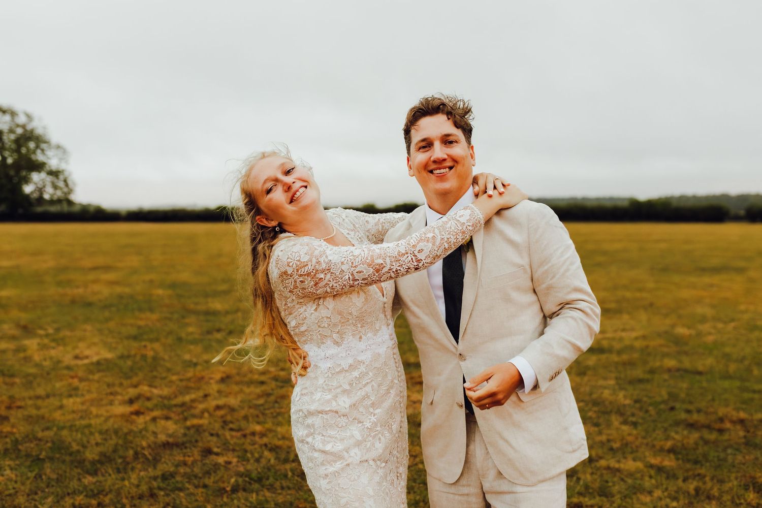 Bride and groom, Rosie and Will, enjoying a quiet moment in a meadow.