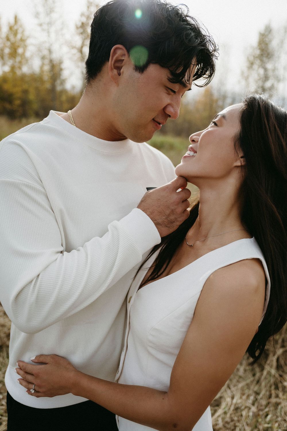 A romantic couple in white outfits share intimate moments in a series of outdoor photos against a natural backdrop.