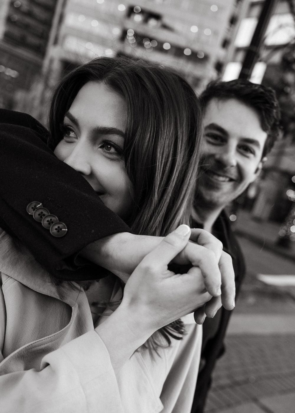A black and white photo sequence shows a couple sharing intimate moments and laughter together in an urban setting.