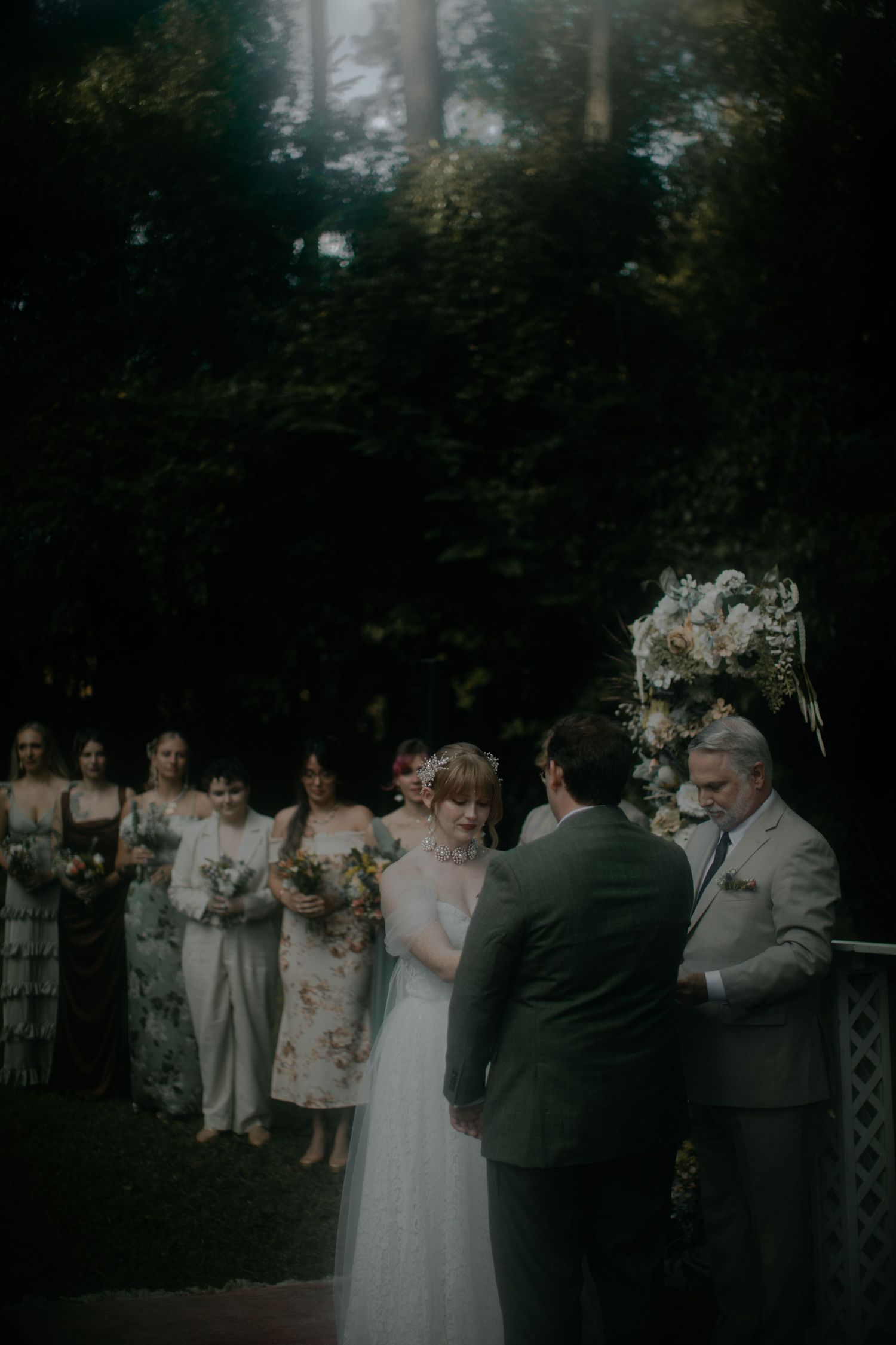 Wedding party gathers outside during twilight celebration with elegant decor.
