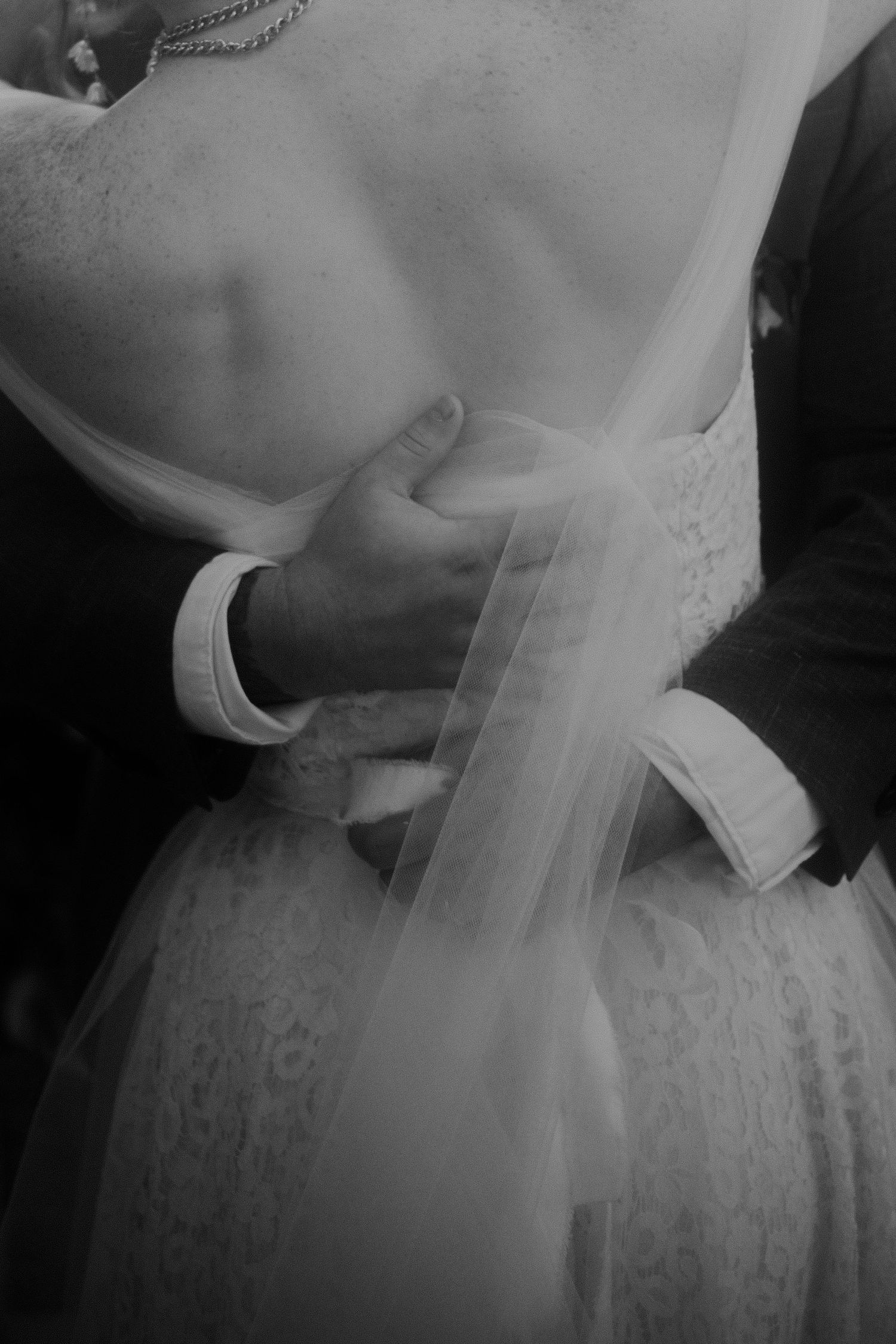 Close-up details of a white lace wedding dress with delicate beading and tulle.