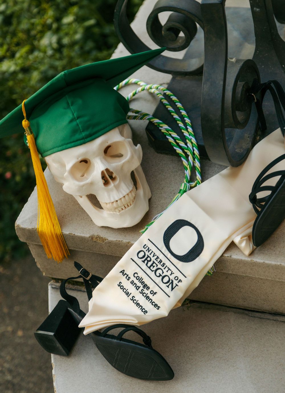 University of Oregon graduation cap and diploma sash on decorative skull, College of Arts and Sciences Social Science.