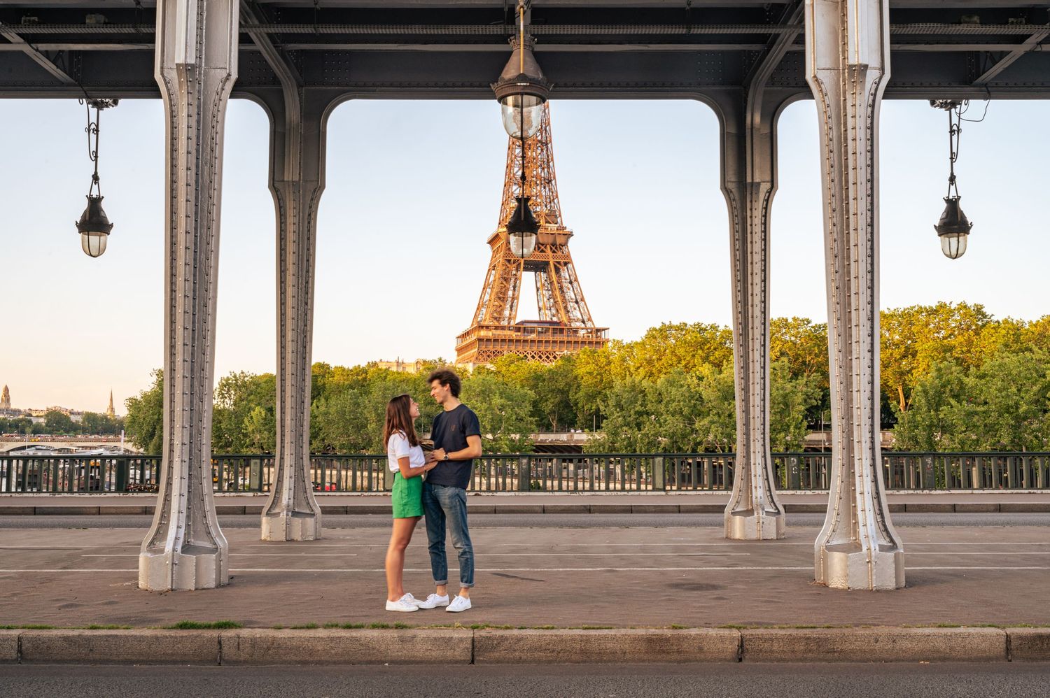 Couple sharing a romantic moment on Bir Hakeim bridge with the Eiffel Tower backdrop in Paris.