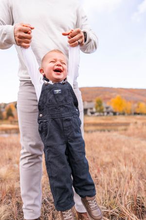 salt lake city utah family photographer, candid photo of a dad swinging toddler in the mountains