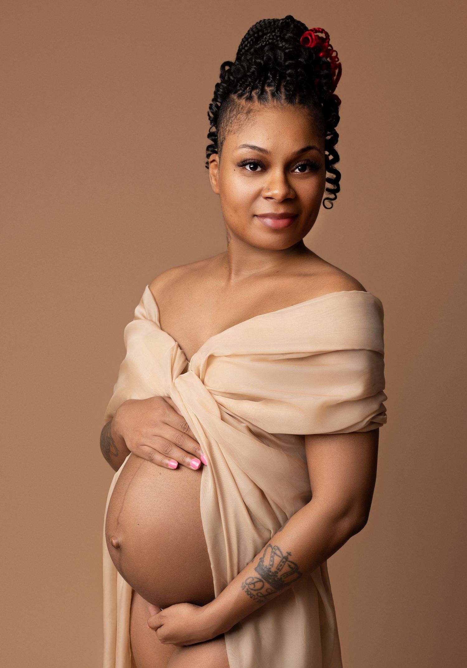 Gorgeous Smiling Mother cupping her belly with one hand rested on top and one hand underneath.