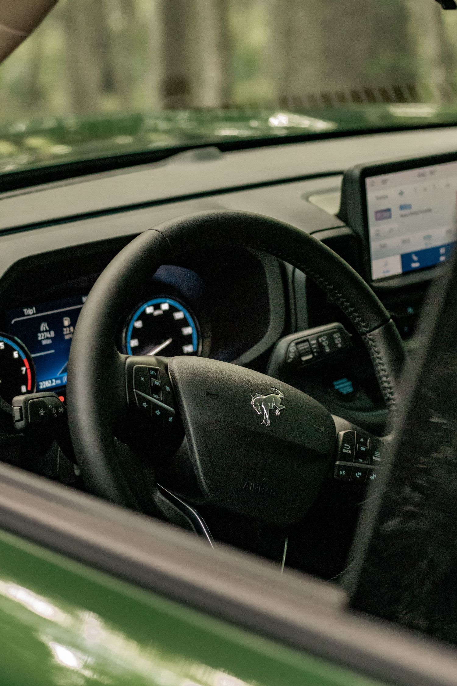 Interior dashboard view of a Ford Bronco Sport showing the steering wheel and digital display.