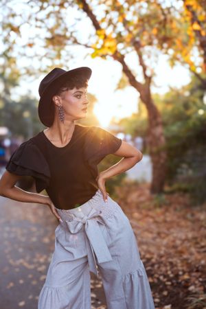 A woman poses with her hands on her hips during golden hour in an individual portrait session with Krystal Roina Photography.