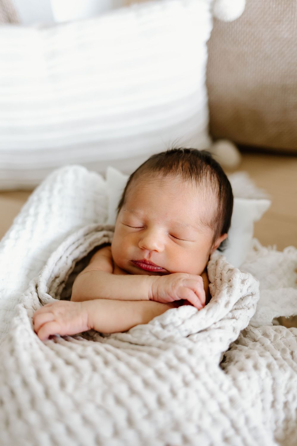 Close-up series of a sleeping newborn baby on soft white textured blanket.