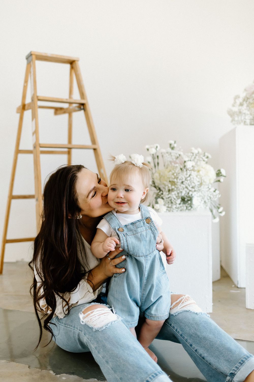 A series of candid moments between a parent and child wearing matching denim against a white backdrop.