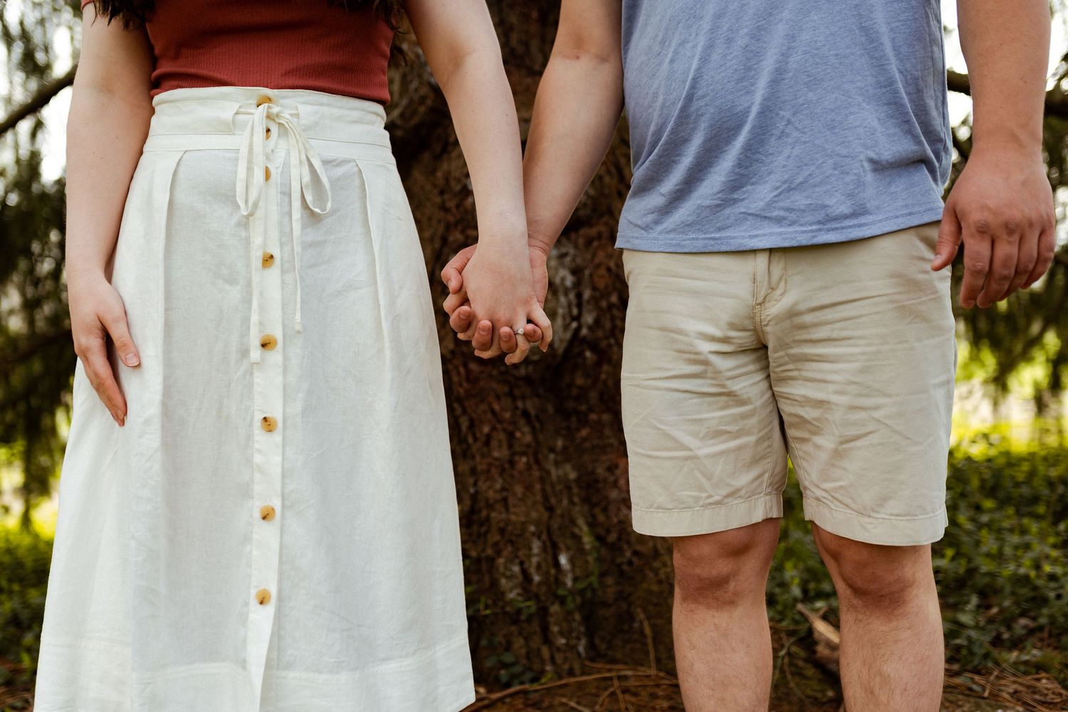 Close-up of casual summer outfits showing white dress and khaki shorts.