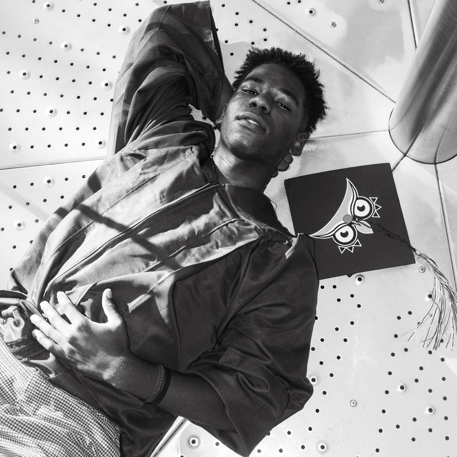 Black and white low angle portrait shot of someone wearing a casual jacket against a textured background.