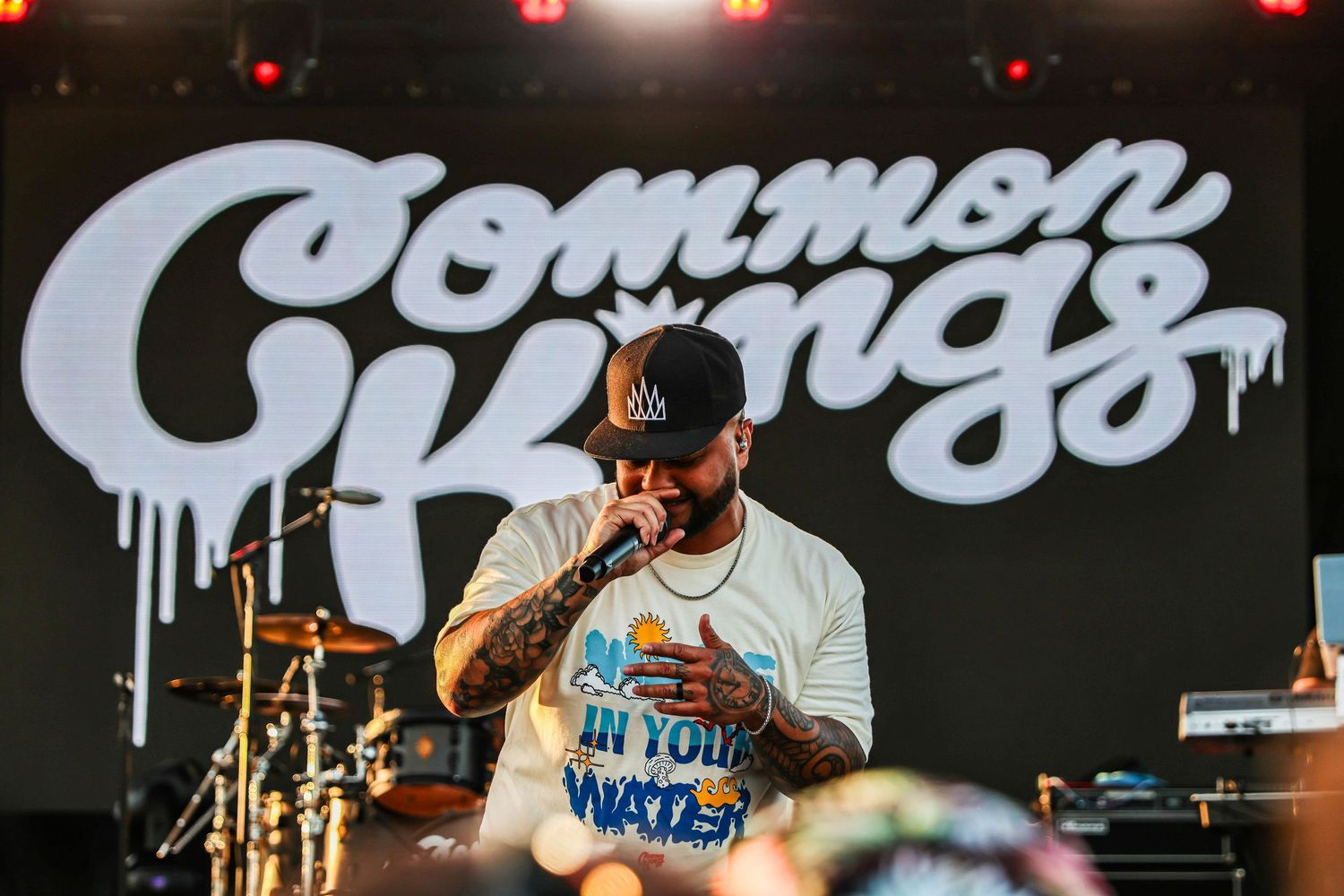 San Diego live music photography of Common Kings performing on stage at Bayfest with a large band logo in the background.