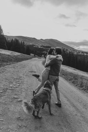 A playful sequence shows a dog and person interacting on a mountain trail with rolling hills in the background.