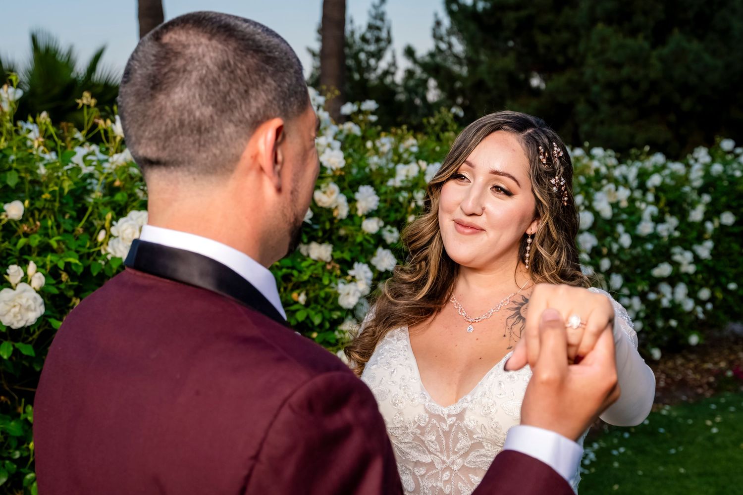 A romantic wedding dance moment captured in a garden setting with white flowers in the background. granada hills.
