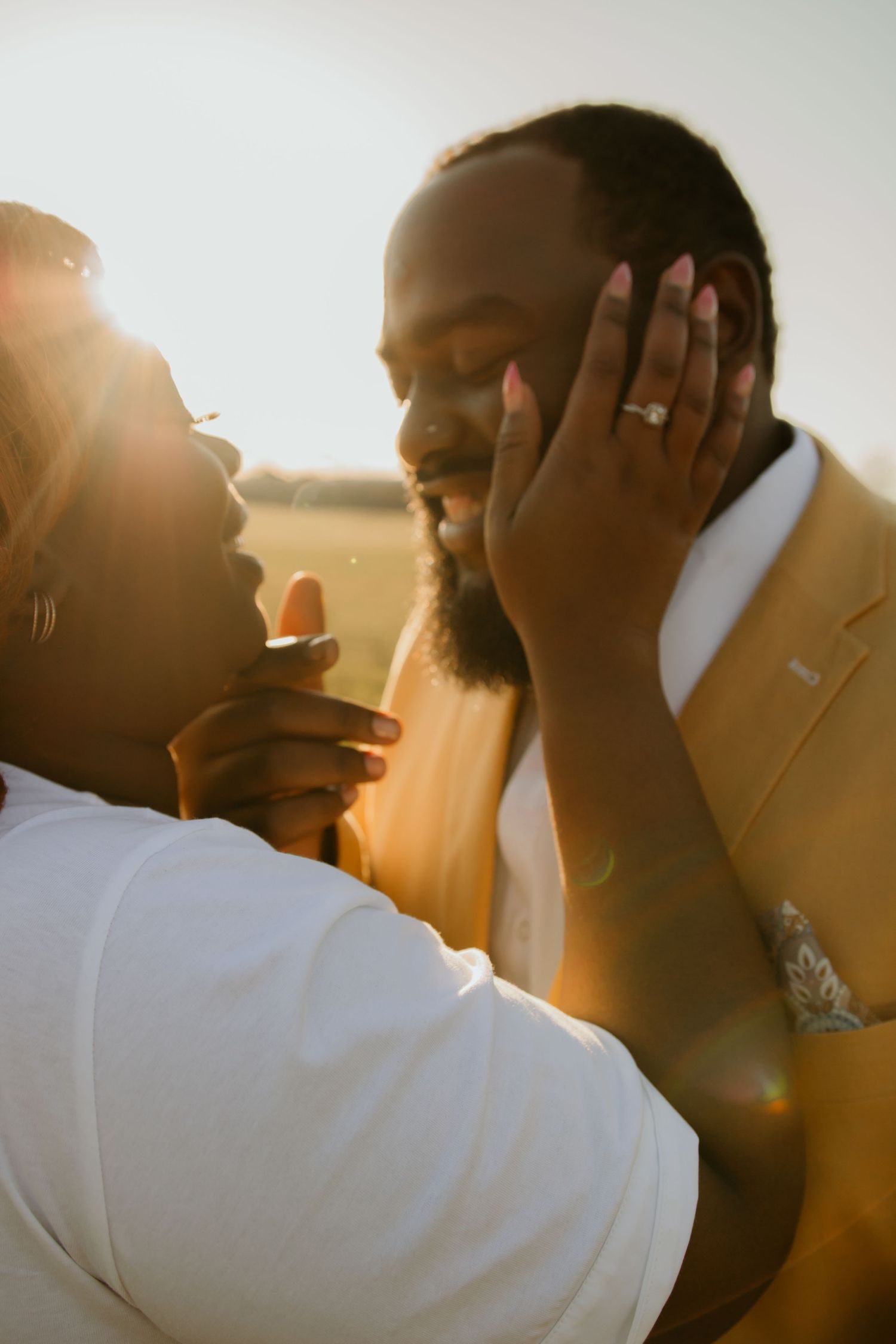 Intimate couple sharing a sweet moment at sunset with sunlight glowing behind them in a romantic embrace in Bloomfield, Connecticut.