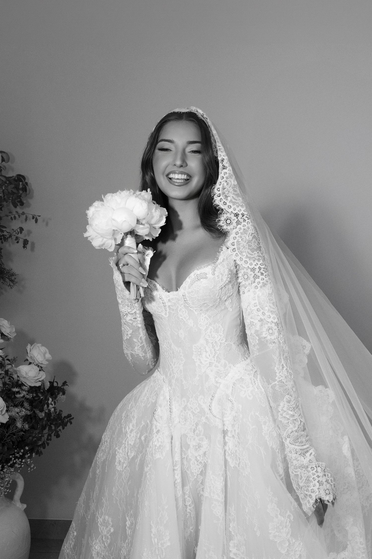 Elegant black and white photo of a bride in a flowing wedding gown surrounded by billowing white fabric.