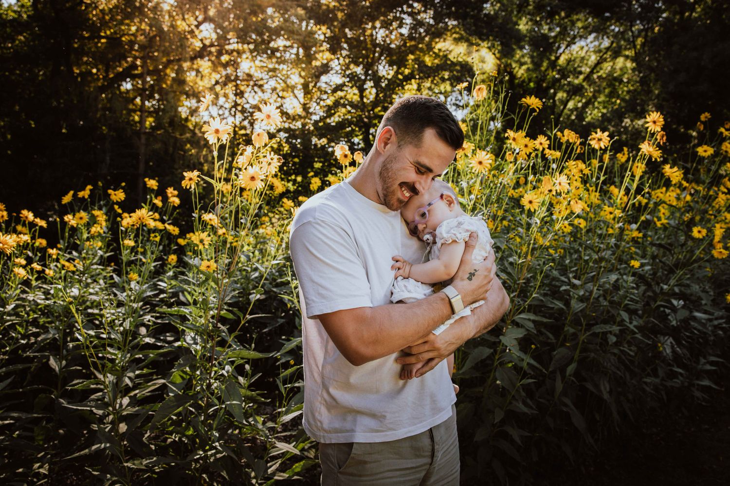 A couple shares tender moments in a golden sunlit garden setting during their engagement photo session.