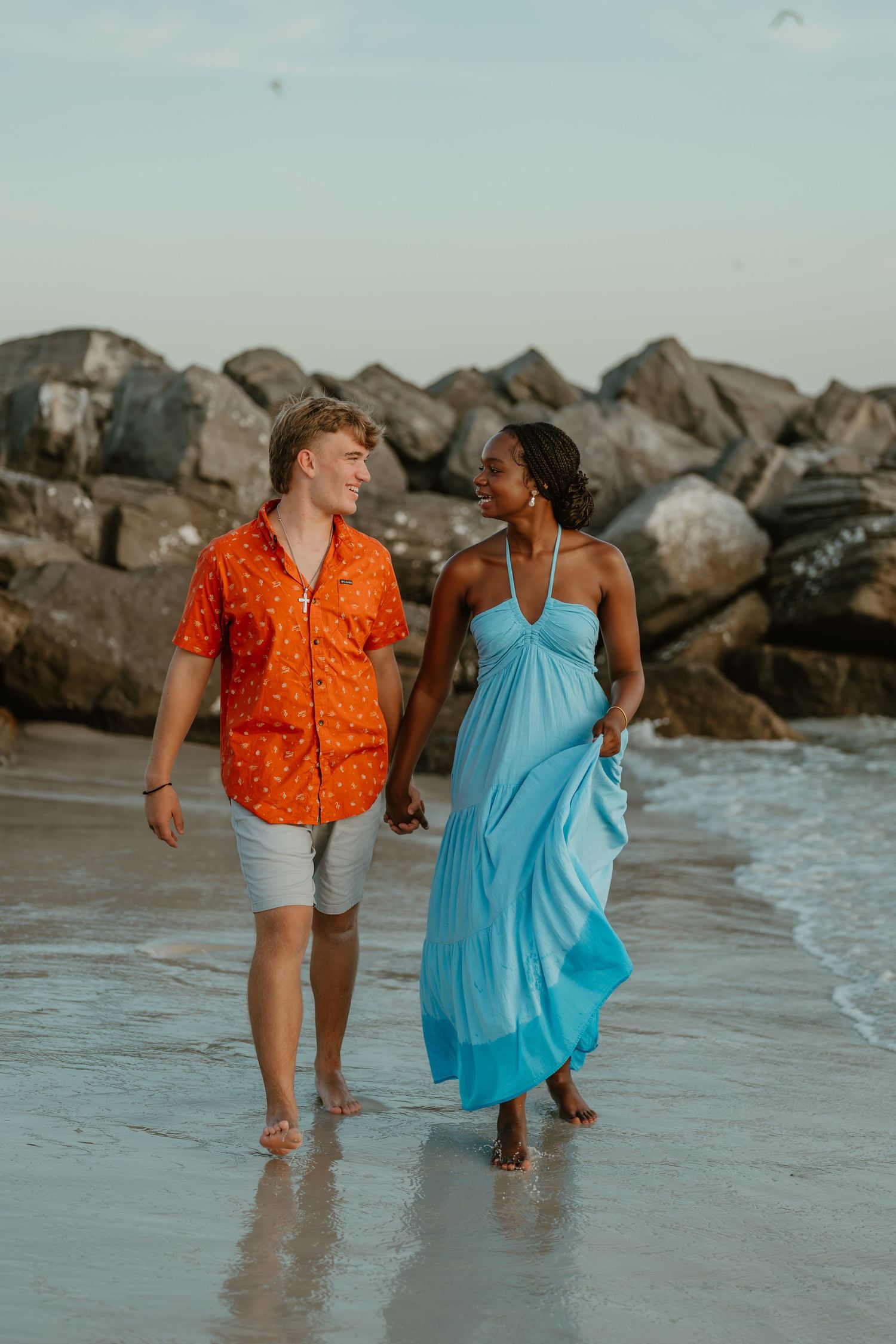 Couple walking along the shoreline at St. Andrews State Park in Panama City Beach, Florida.