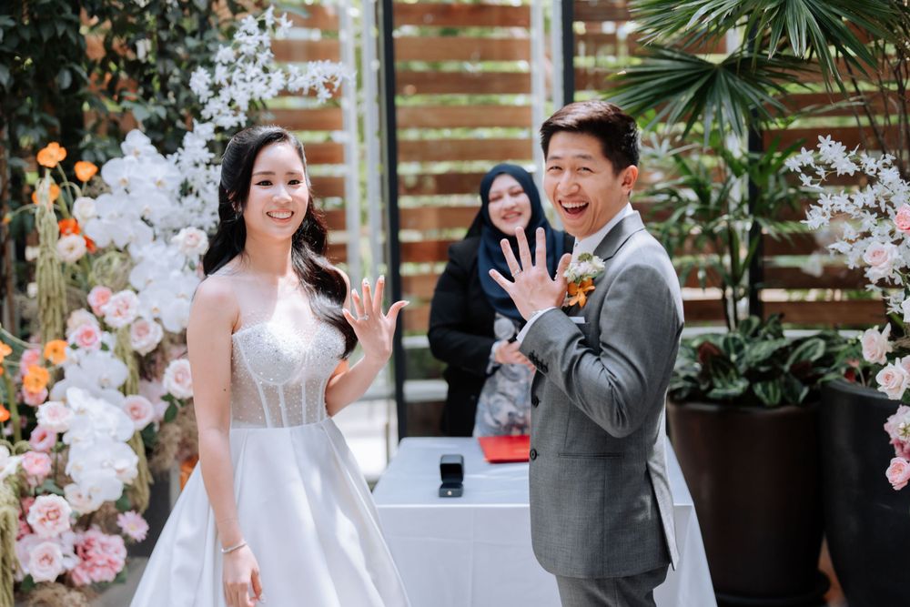 Wedding couple shares enthusiastic moment during ceremony with floral decorations.