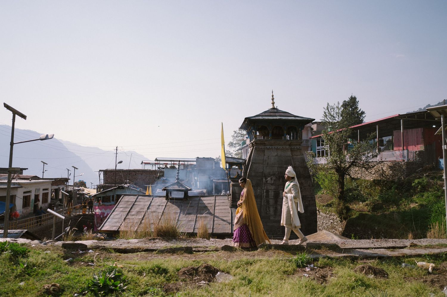 Scenic mountain village with pagoda tower against misty mountain backdrop.