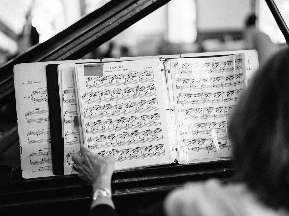 Sheet music displayed on a piano stand shown in black and white.