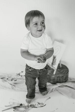Black and white series showing a small toddler in white shirt and jeans playing on a light colored floor.
