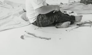 Black and white photo sequence of a toddler exploring and crawling on a light surface.
