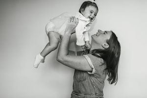 Black and white photo sequence showing a parent playfully lifting and holding a small baby in the air.