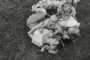 A series of black and white photographs showing a person rolling down a grassy hill in vintage clothing.