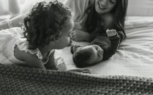 A series of black and white photos showing tender moments between two people lying close together.