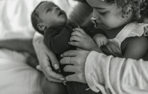 A series of black and white photographs showing intimate moments of a parent and baby interacting together.