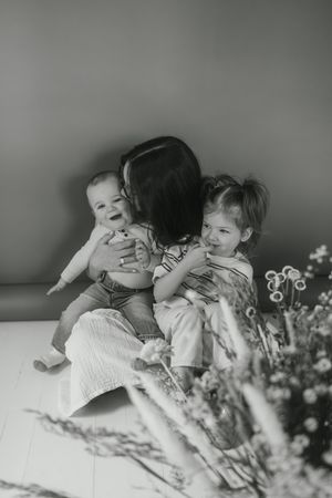 Black and white photos capture tender family moments with flowers in foreground.
