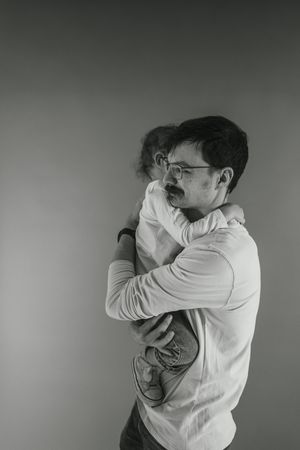 A sequence of black and white photos shows a person in a white shirt turning away and covering their face.