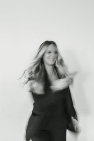 Motion blur sequence of a person in black clothing dancing against a white background.