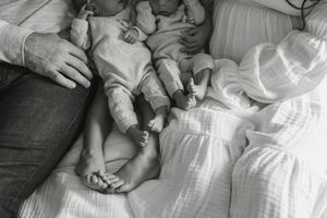 A series of black and white photographs showing a baby's feet and hands being gently held.