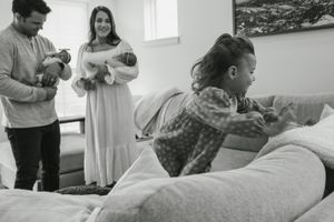 A group of people gather in a bright room for what appears to be a celebration or gathering.