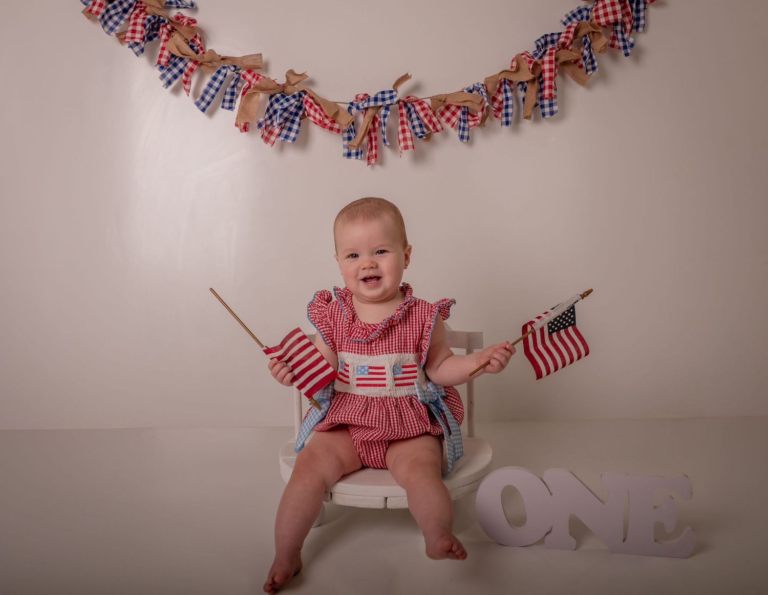 A baby's first birthday setup with blue hot air balloon decorations and smash cake.