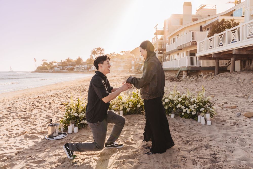 surprise proposal with man kneeling on one knee asking to marry his girlfriend in Santa Barbara, Ca on the beach