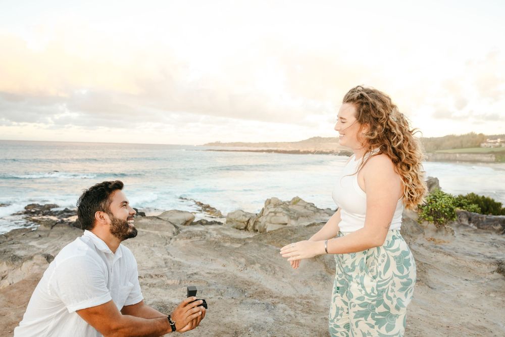 A man proposes to his fiancé during a beautiful maui sunset. surprise engagement