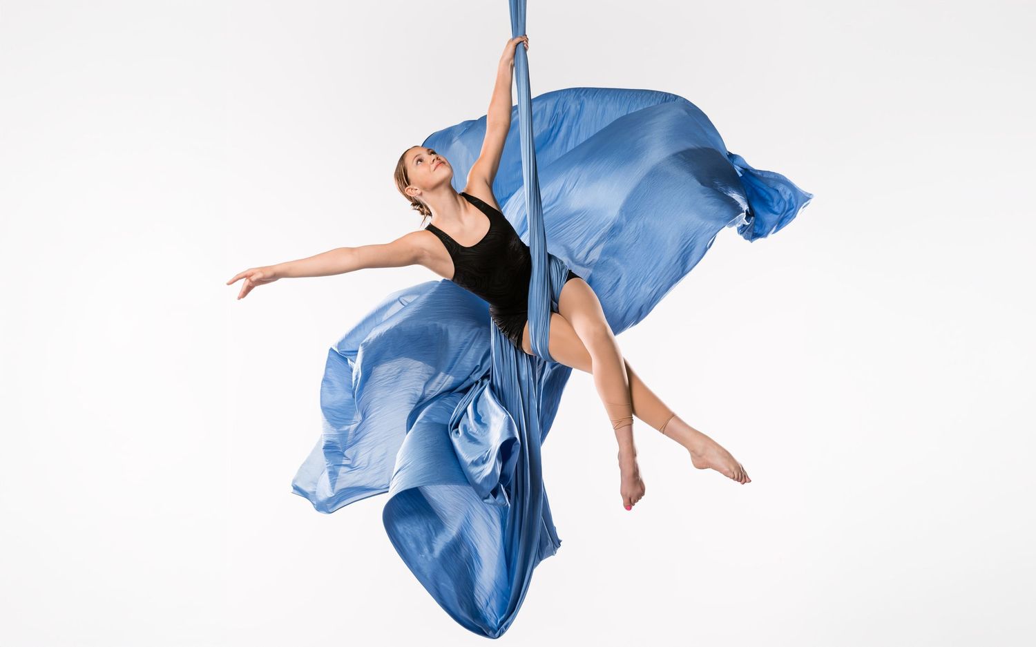 Studio aerial arts photography; aerialist on white backdrop captured in professional aerialist photoshoot and polished aerial portraits.