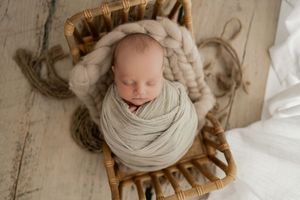 Serene newborn photo session with soft beige tones and natural window light.