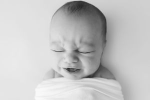 Close-up black and white portraits of a sleeping infant showing peaceful expressions and delicate features.