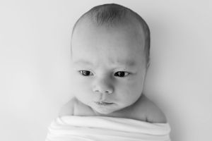 Series of tender black and white photographs capturing an infant's gentle expressions and soft features.