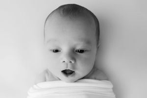 Black and white collage showing close-up portraits of an infant with various facial expressions.